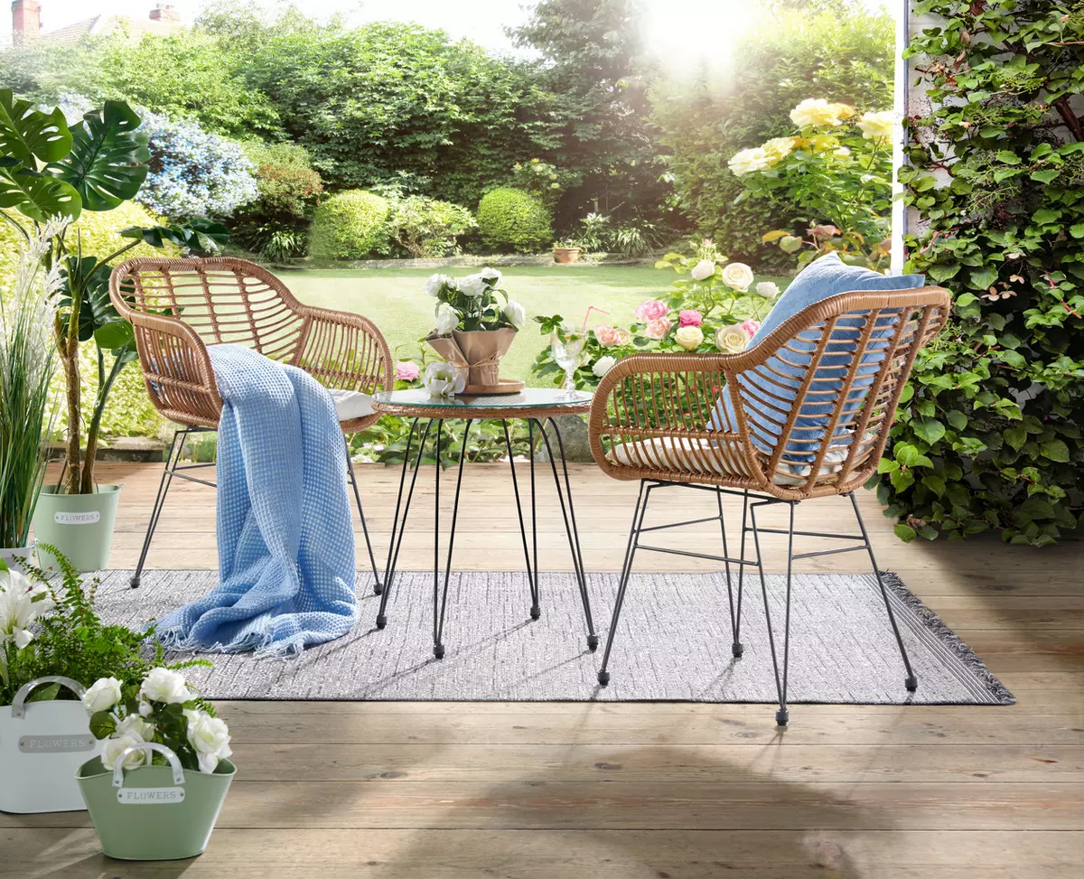 Balkonmöbel mit einem Tisch aus Glas und zwei Stühlen in geflochtener Boho-Optik und schwarzem Metallgestell von Ambia Garden