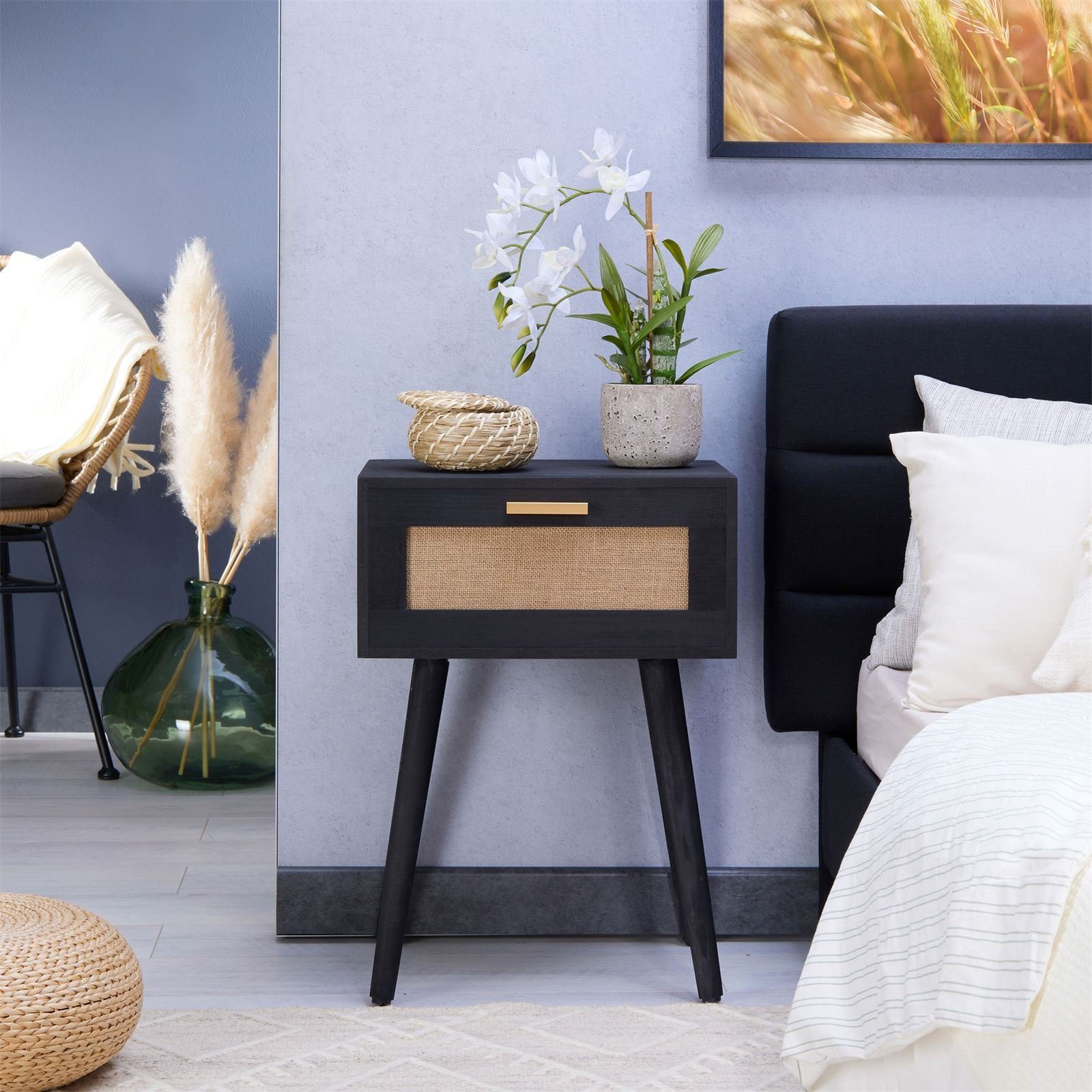Boho-Style Nachttisch Kiran aus Rattan und schwarzen Holz mit Schubladen, bier Holzbeinen und goldenem Griff von CARO-Möbel in einem modernen Schlafzimmer
