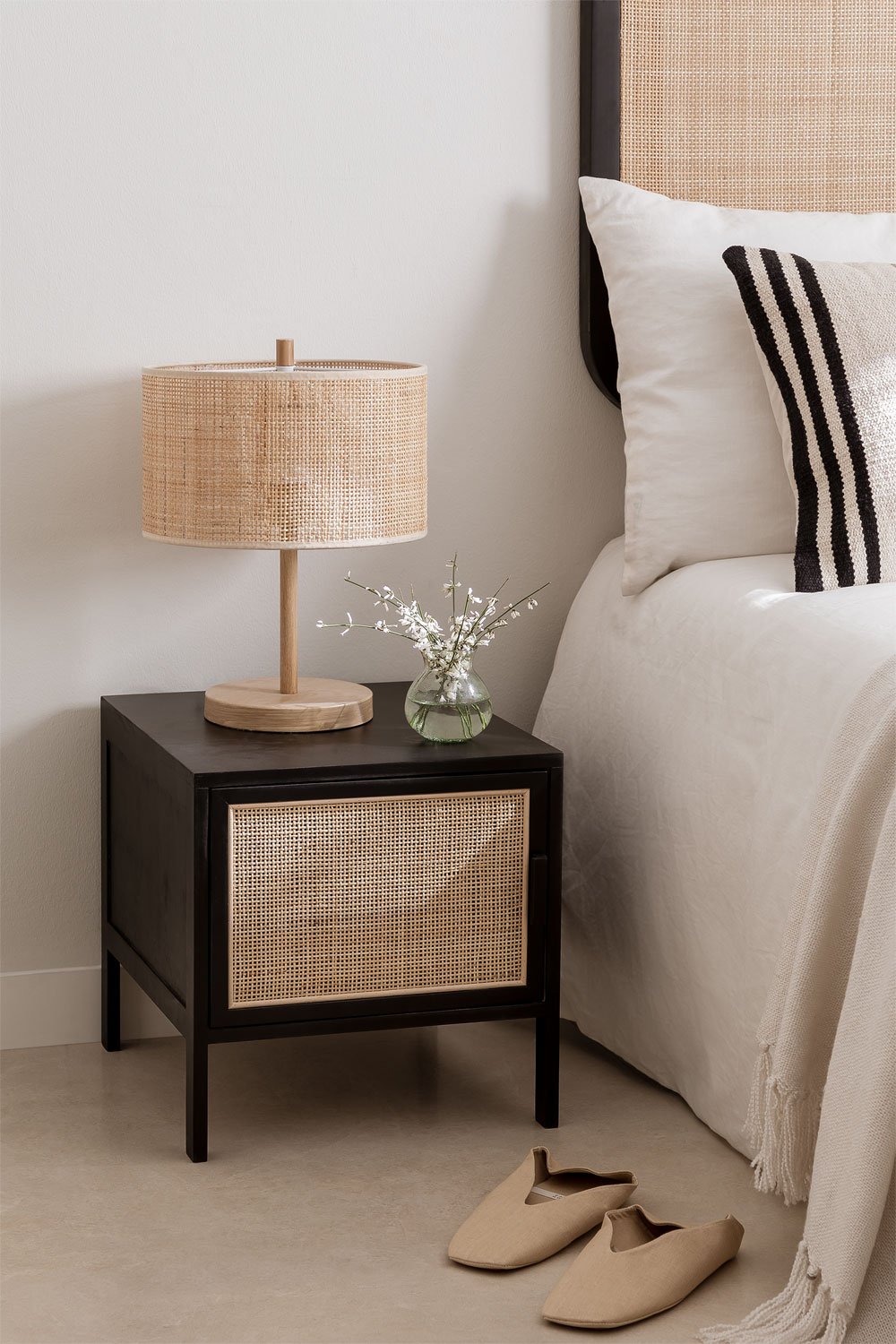 Boho-Style Nachttisch Reyna in Rattan und schwarzen Holz mit einem Fach/Schrank und vier schwarzen Beinen für einen modernen Look von SKLUM in einem beigen Schlafzimmer